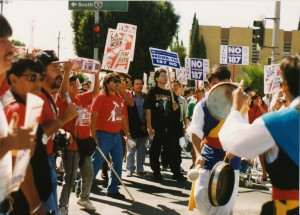 A group of marchers from the Justice for Janitors look on as a Korean musician performs.