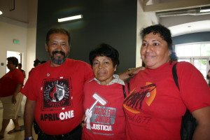 Three older Latinx folks in red union t-shirts.