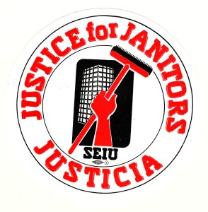 White circular stick with red lettering reading "Justice for Janitors -- Justicia." In the center of the circle is a black design of a modern skyscraper with a red fist rising over it holding a mop. There's a union slug under SEIU at the bottom.