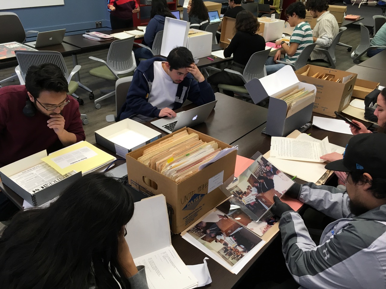 Students read from files drawn from archival boxes