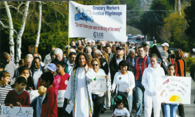 Banner image of a march of religious leaders and families, under a banner at the center reading "Grocery Workers Justice Pilgrimage -- "Do not close your ears to the cry of the needy" and bearing the logo of CLUE (Clergy and Laity United for Economic Justice). At the front of the march is CLUE's leader Rev. Alexia Salvatierra.